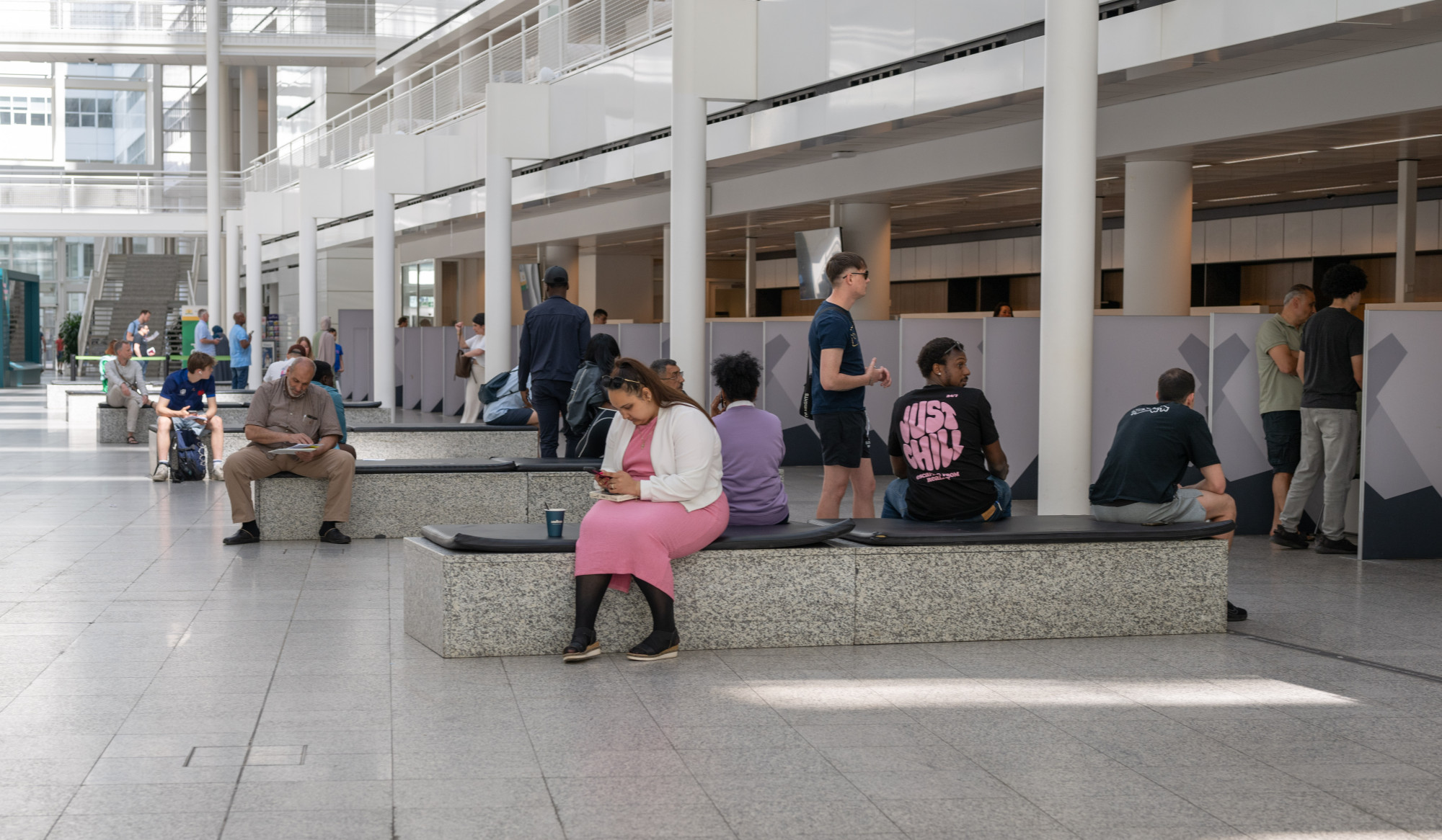 Personen bij en wachtend voor loketten in gemeentehuis